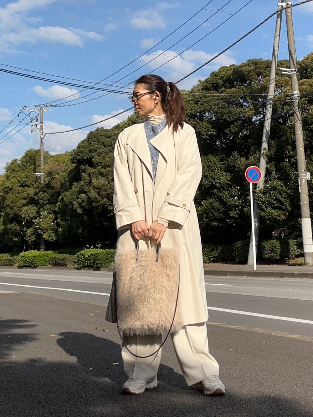 ブルー系のニット/セーター、ホワイト系のノーカラーコート、ホワイト系のスラックスを着用したレディースの秋コーディネートの2枚目の写真