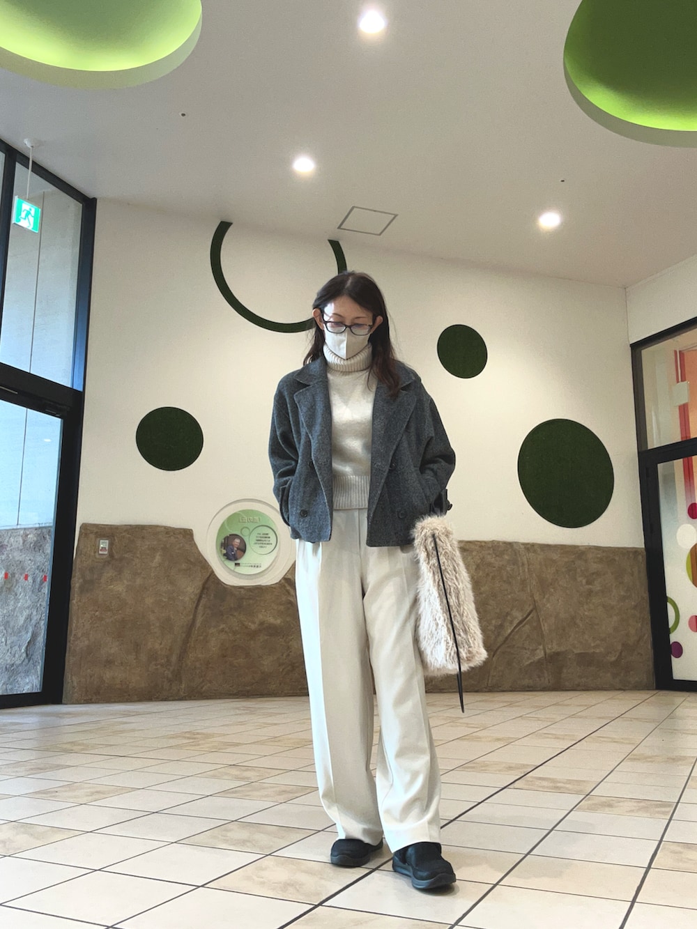 ホワイト系のニット/セーター、ホワイト系のスラックス、ブラック系のスニーカーを着用したレディースの秋コーディネートの2枚目の写真