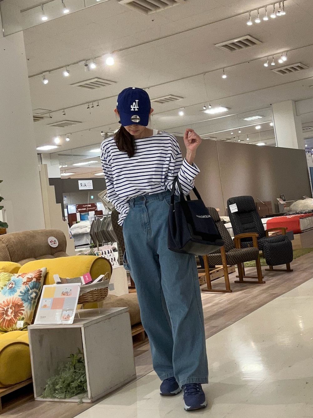 ブルー系のスニーカーを着用したレディースの春コーディネートの2枚目の写真