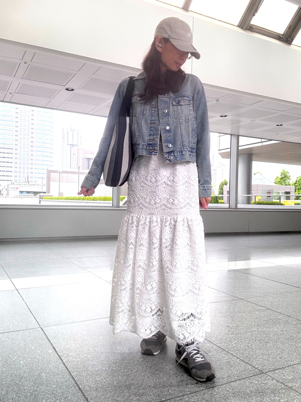 その他のトートバッグ、ホワイト系のスカート、グレー系のスニーカーを着用したレディースの春コーディネートの2枚目の写真