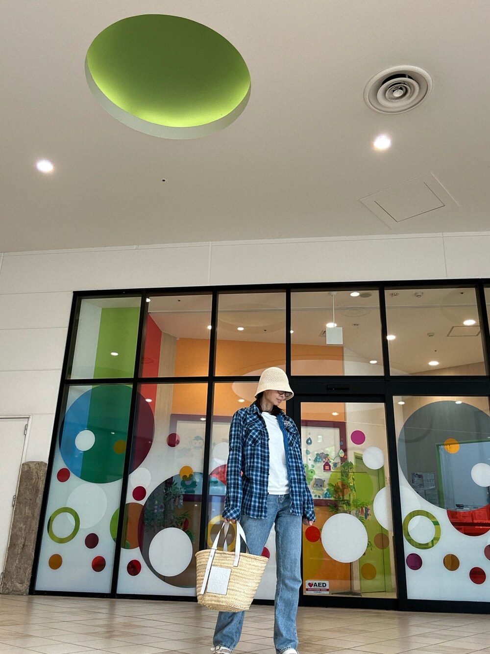 ホワイト系のTシャツ/カットソー、ブルー系のデニムパンツ、ホワイト系のかごバッグを着用したレディースの夏コーディネートの2枚目の写真