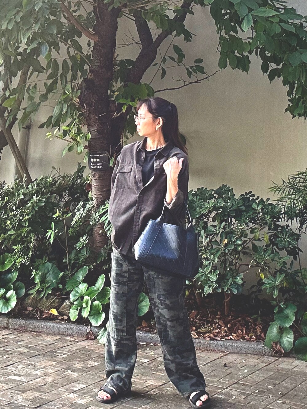 ブラック系のトートバッグ、グリーン系のカーゴパンツ、グリーン系のシャツ/ブラウスを着用したレディースの秋コーディネートの3枚目の写真