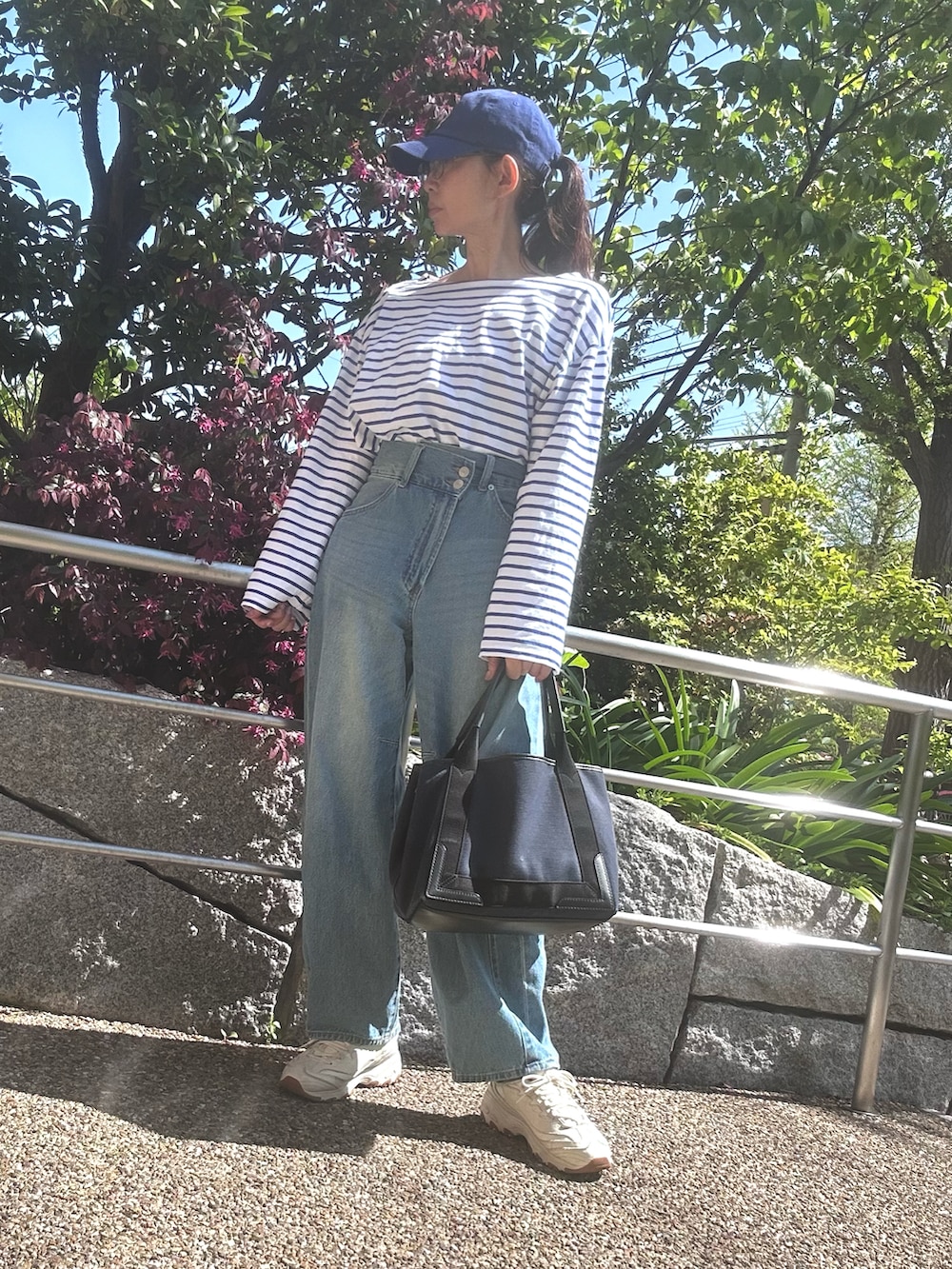 ブルー系のTシャツ/カットソー、ブルー系のデニムパンツ、ホワイト系のスニーカーを着用したレディースの春コーディネートの2枚目の写真