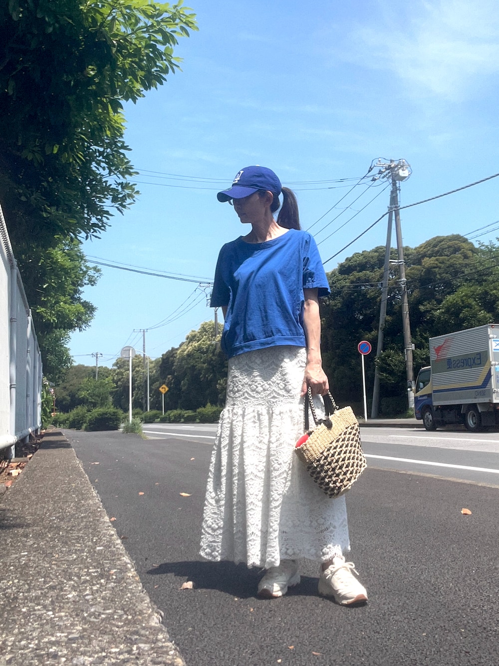 ブルー系のTシャツ/カットソー、その他のかごバッグ、ホワイト系のスニーカーを着用したレディースの夏コーディネートの2枚目の写真