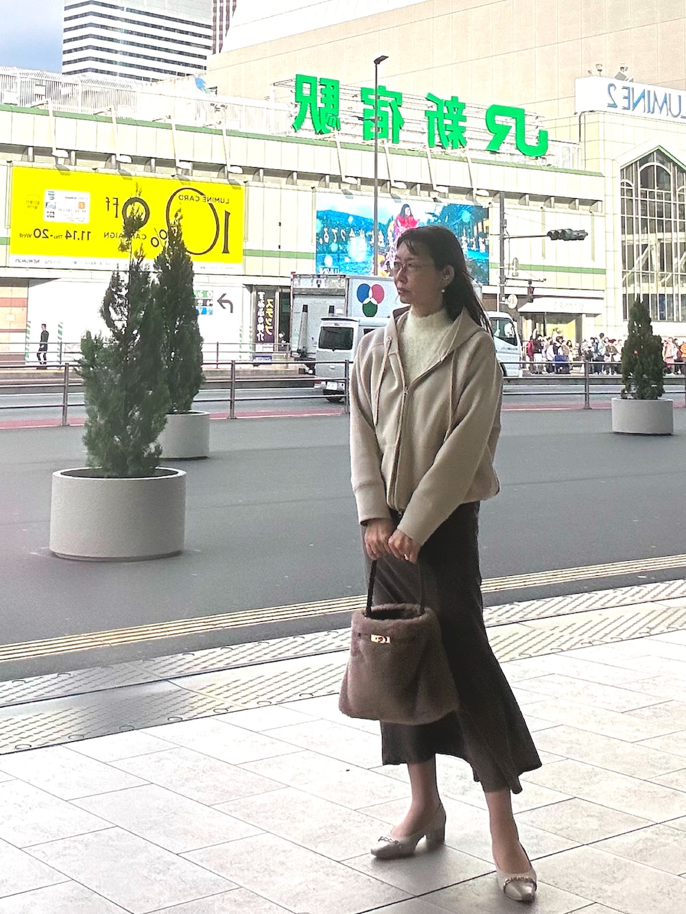 ベージュ系のハンドバッグ、ホワイト系のニット/セーター、グレー系のスカートを着用したレディースの秋コーディネートの2枚目の写真