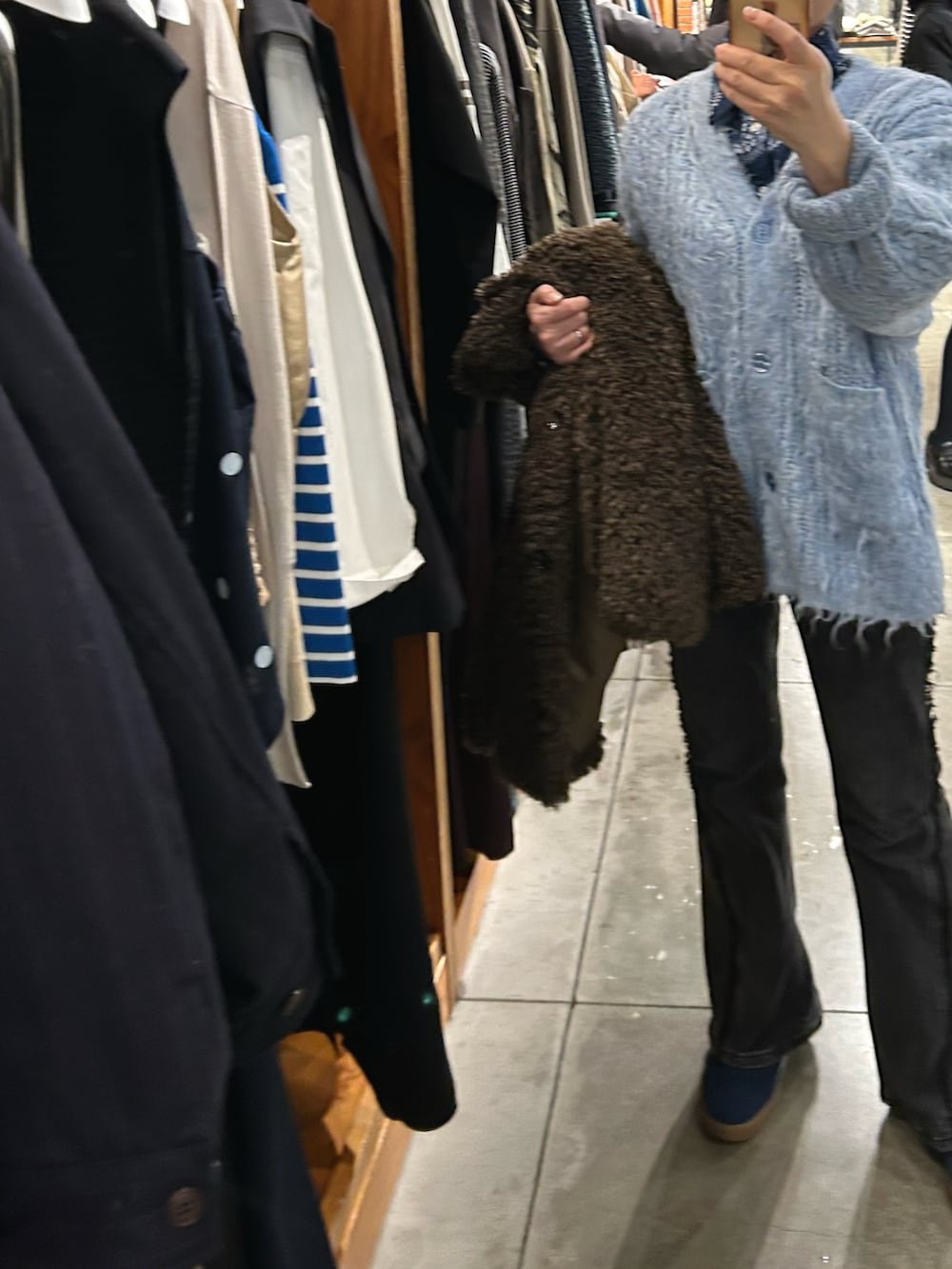 ブラック系のデニムパンツ、ブルー系のカーディガン/ボレロ、ブルー系のシャツ/ブラウスを着用したレディースの冬コーディネートの2枚目の写真