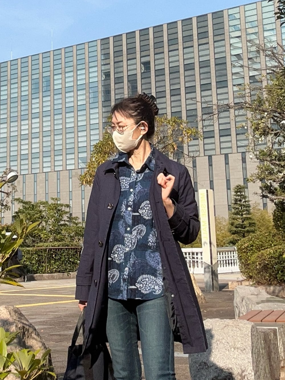 ブルー系のトレンチコート、ブルー系のシャツ/ブラウスを着用したレディースの春コーディネートの2枚目の写真