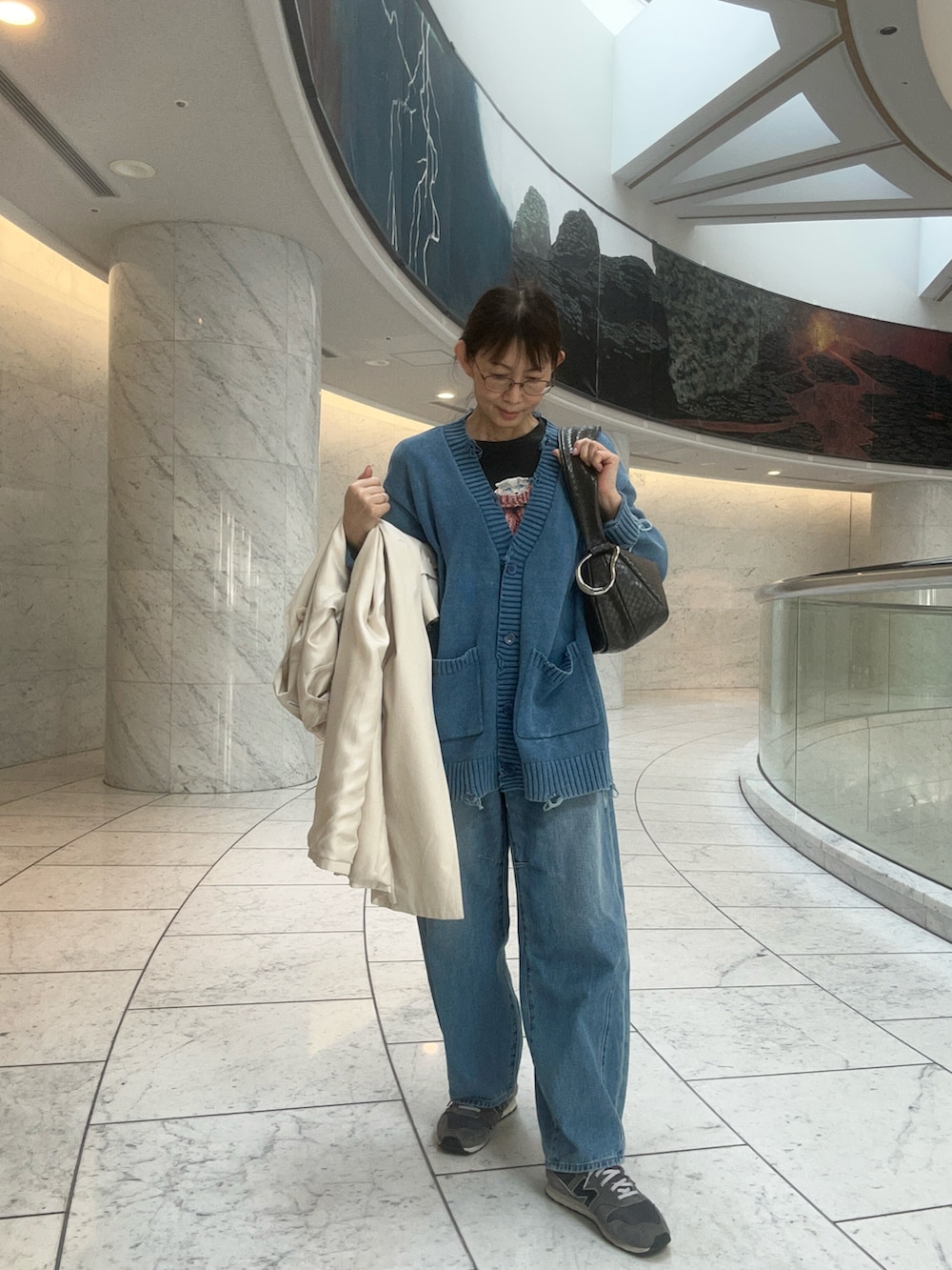 グレー系のショルダーバッグ、ブルー系のカーディガン/ボレロ、ホワイト系のノーカラーコートを着用したレディースの春コーディネートの2枚目の写真