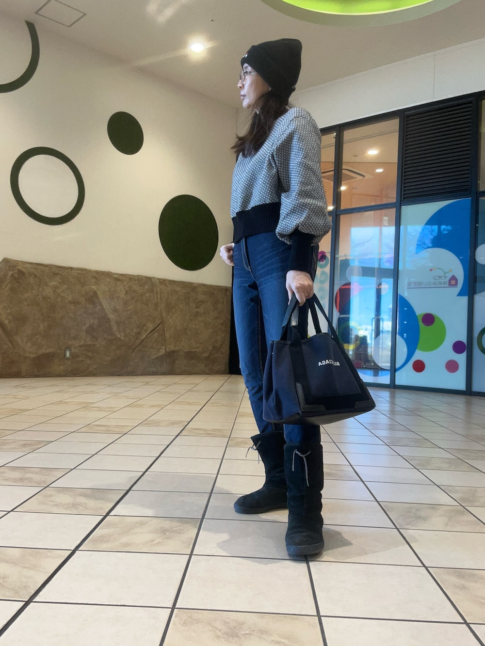 ブルー系のデニムパンツ、ブラック系のブーツ、ブラック系のジャケット/アウターを着用したレディースの冬コーディネートの2枚目の写真