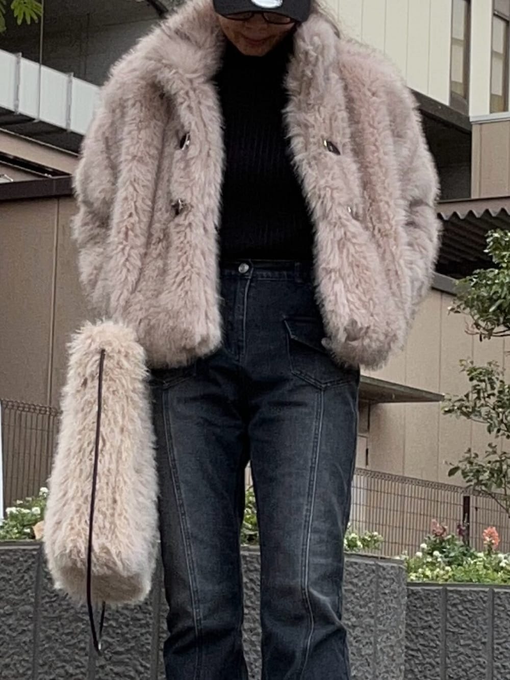 ベージュ系のブルゾン、ベージュ系のトートバッグ、ブラック系のデニムパンツを着用したレディースの冬コーディネートの2枚目の写真