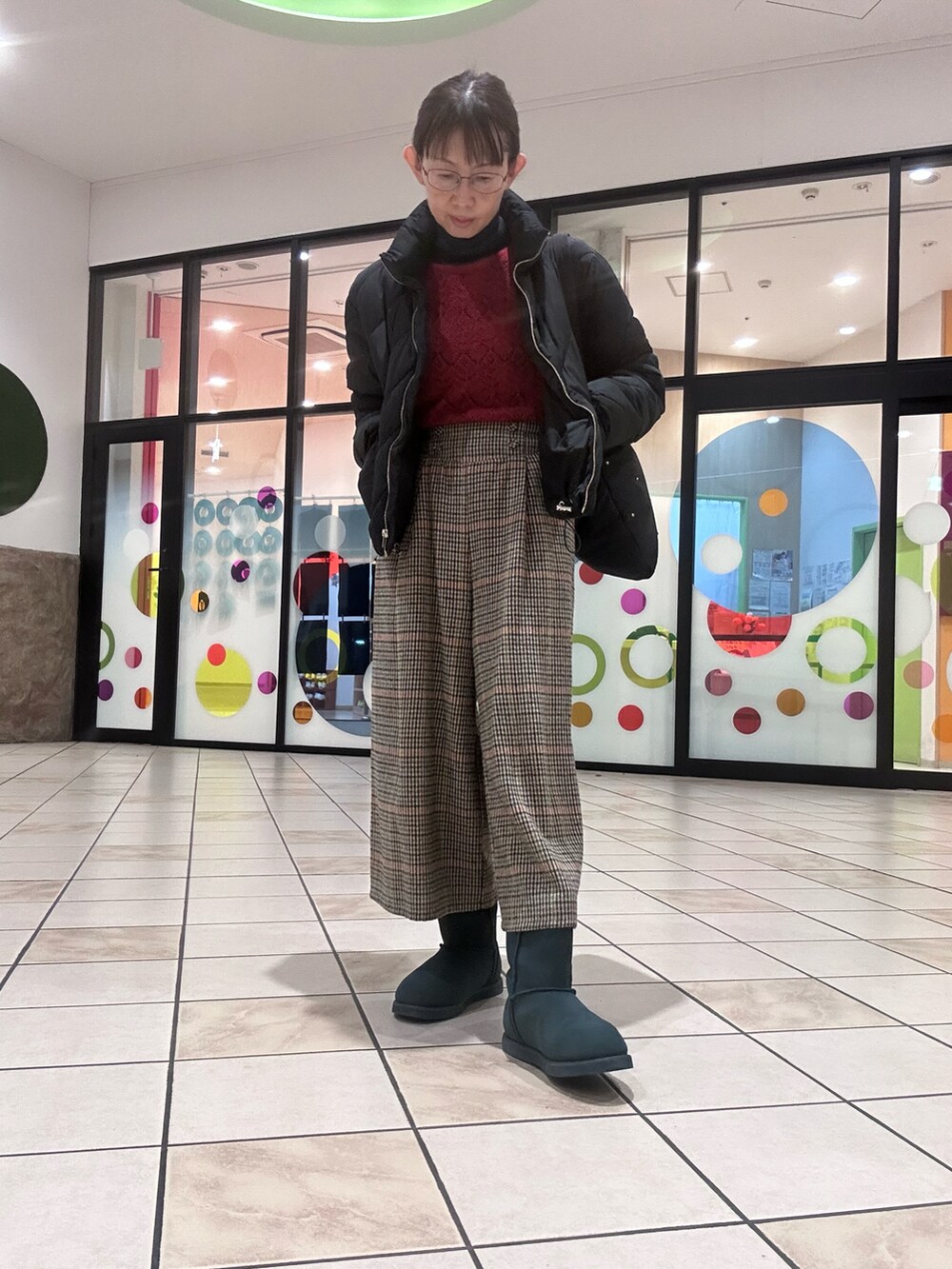 レッド系のニット/セーター、ブラック系のトートバッグ、その他のパンツを着用したレディースの冬コーディネートの2枚目の写真