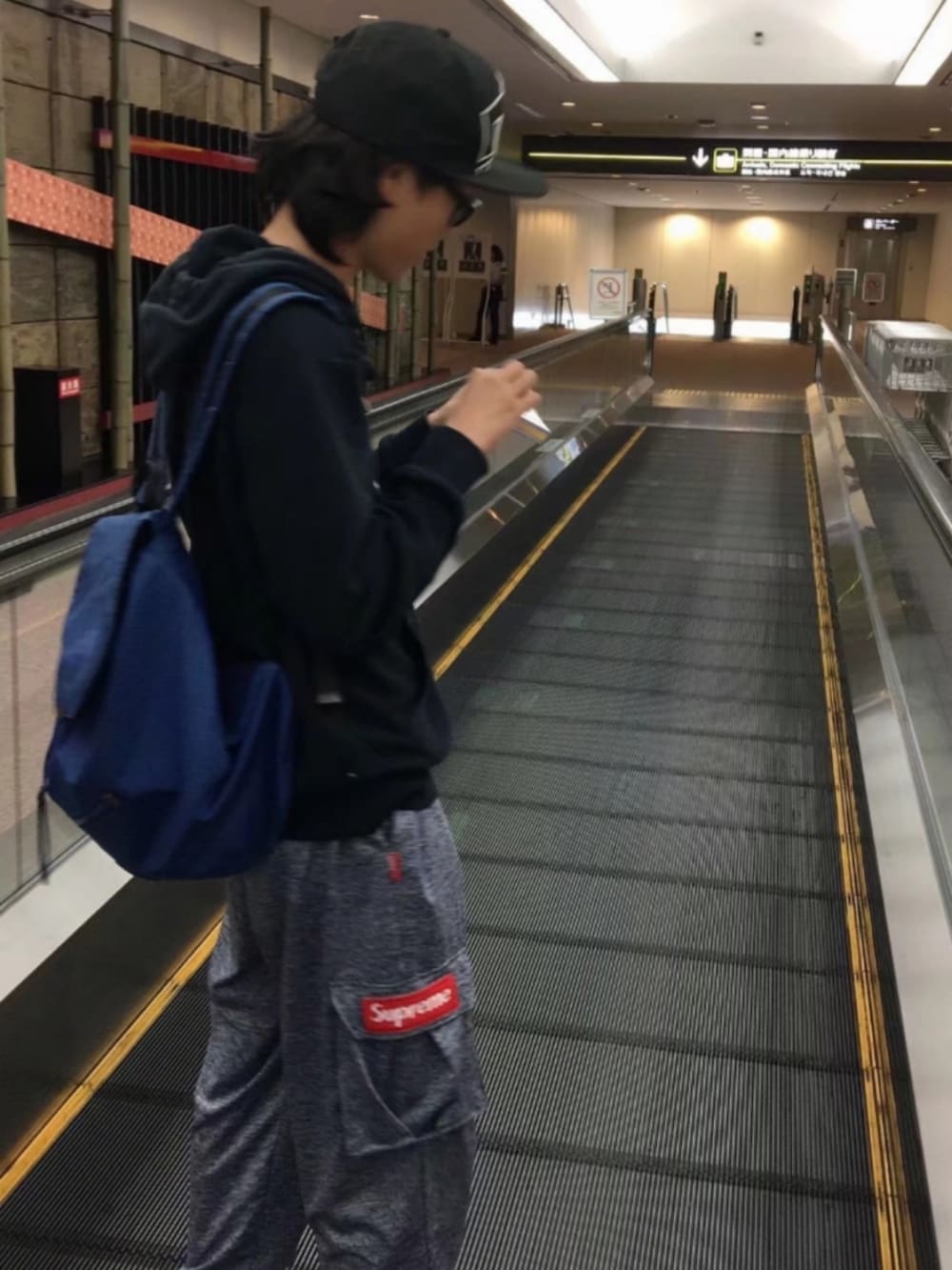 シルバー系のパンツ、ブラック系のシューズ、ブラック系のパーカーを着用したメンズの夏コーディネートの3枚目の写真
