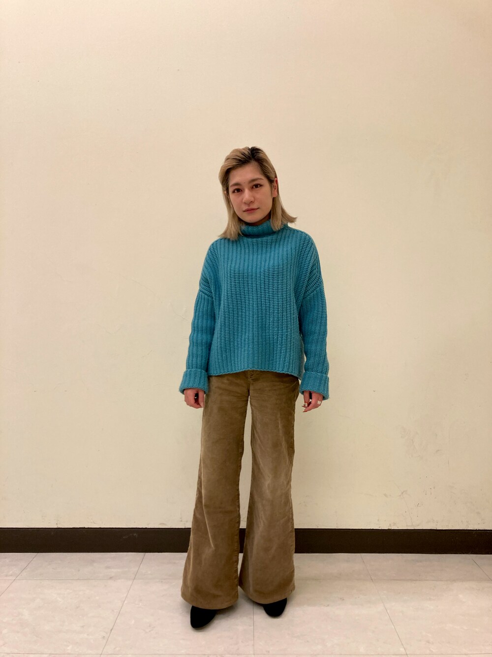 ブルー系のニット/セーター、ベージュ系のデニムパンツを着用したレディースの秋コーディネートの2枚目の写真