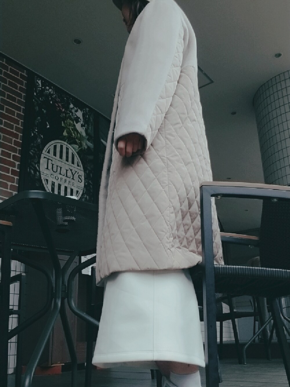 ホワイト系のスカート、ベージュ系のノーカラーコート、ベージュ系のストール/ショールを着用したレディースの春コーディネートの4枚目の写真