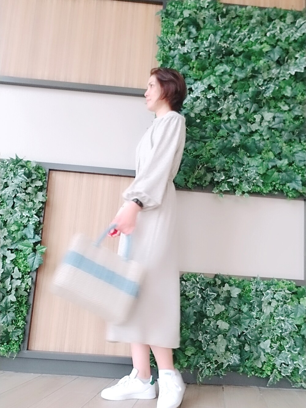 ブルー系のバッグ、グリーン系のスニーカー、ベージュ系のワンピースを着用したレディースの夏コーディネートの2枚目の写真