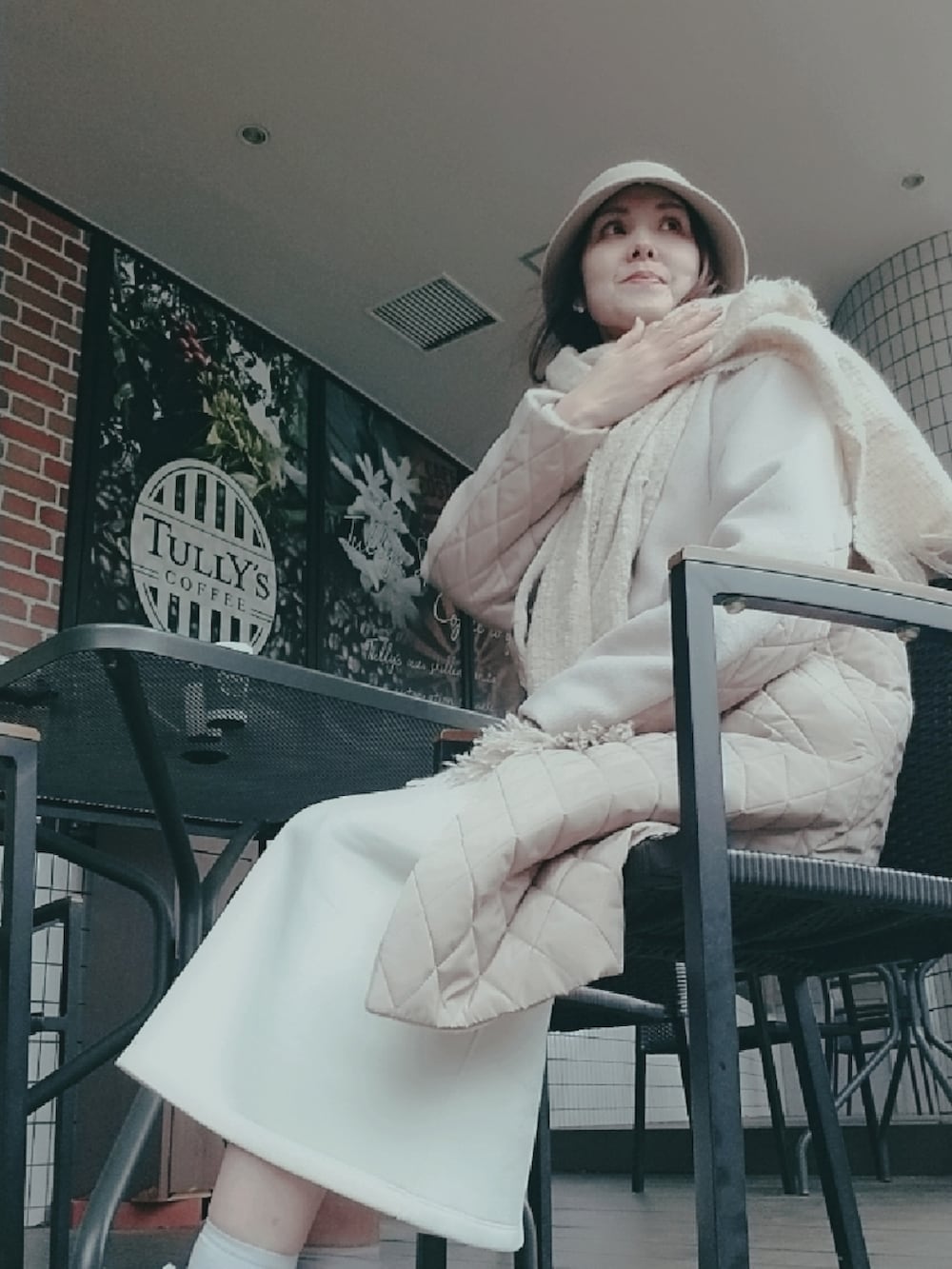 ホワイト系のスカート、ベージュ系のノーカラーコート、ベージュ系のストール/ショールを着用したレディースの春コーディネートの2枚目の写真