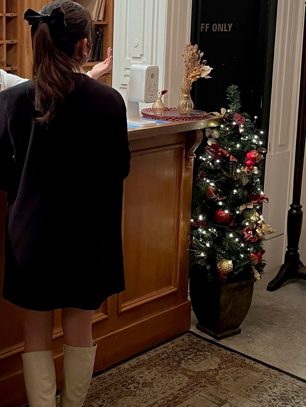 ブラック系のジャケット/アウター、ホワイト系のブーツ、ホワイト系のハンドバッグを着用したレディースの冬コーディネートの4枚目の写真