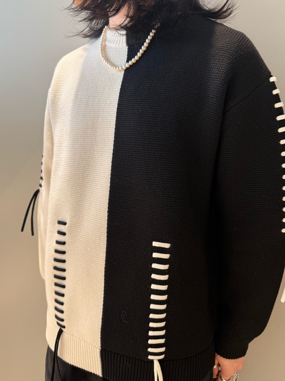 ホワイト系のニット/セーター、ブラック系のデニムパンツを着用したメンズの冬コーディネートの2枚目の写真