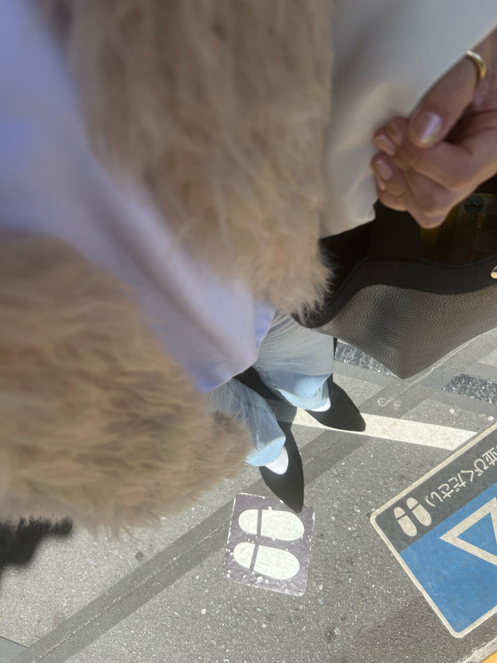 ブラック系のパンプス、ホワイト系のスウェット、ブルー系のデニムパンツを着用したレディースの春コーディネートの2枚目の写真