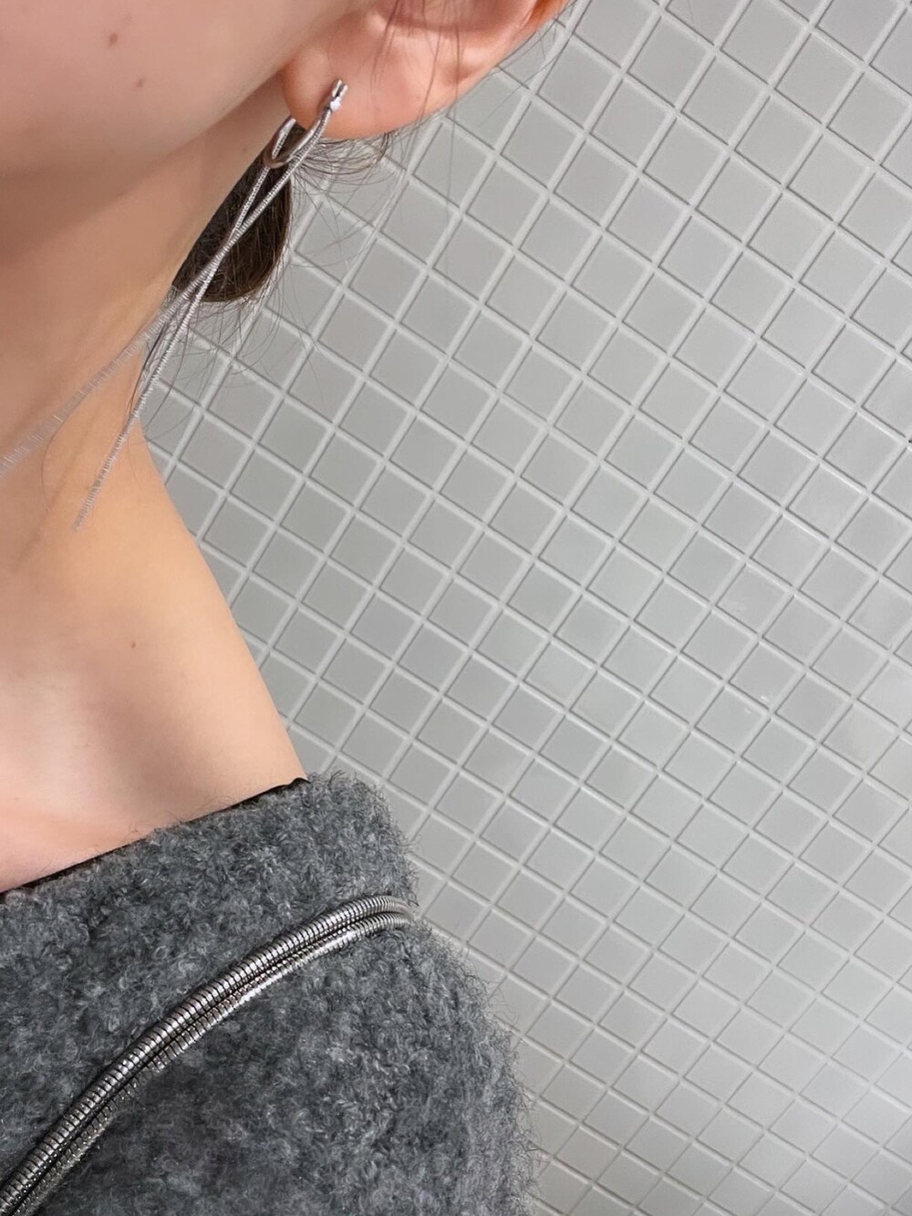 シルバー系のショルダーバッグ、グレー系のその他パンツ、ホワイト系のスニーカーを着用したレディースの冬コーディネートの2枚目の写真