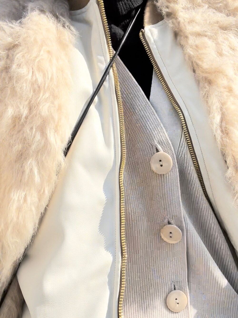 ベージュ系のMA-1、ホワイト系のカーディガン/ボレロ、ベージュ系のベストを着用したレディースの冬コーディネートの2枚目の写真