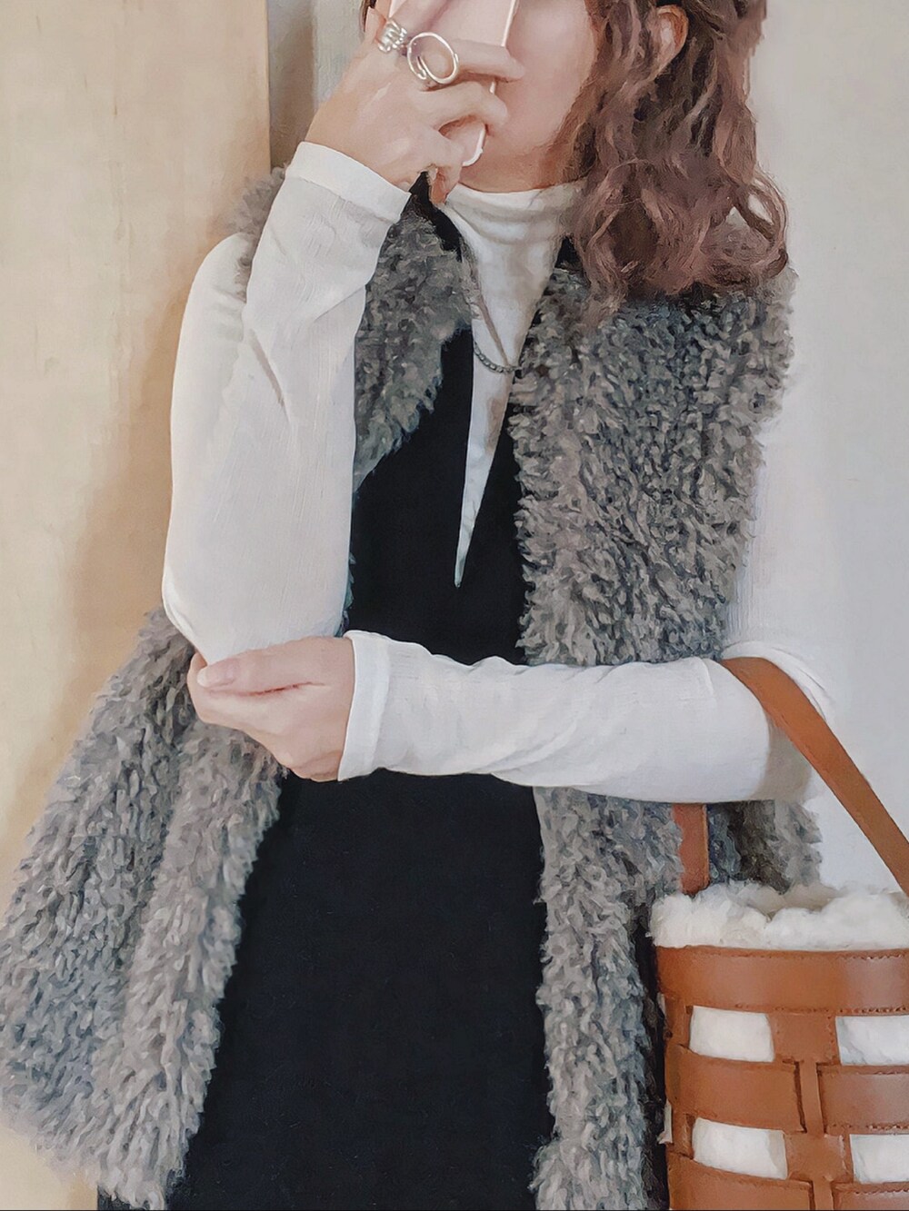 ホワイト系のTシャツ/カットソー、ブラウン系のベスト、ブラック系のワンピースを着用したレディースの秋コーディネートの2枚目の写真