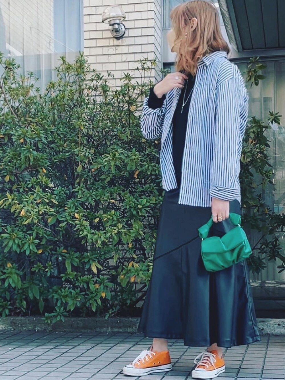 ブルー系のシャツ/ブラウス、ブラック系のスカート、オレンジ系のスニーカーを着用したレディースの春コーディネートの2枚目の写真