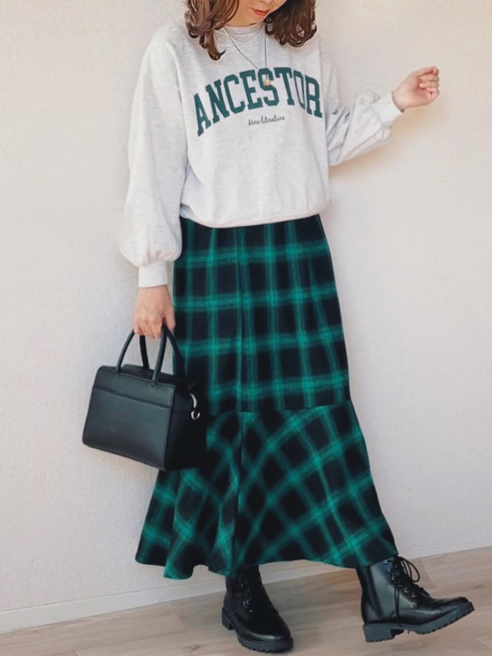 ブラック系のノーカラーコート、グレー系のスウェット、グリーン系のスカートを着用したレディースの冬コーディネートの2枚目の写真