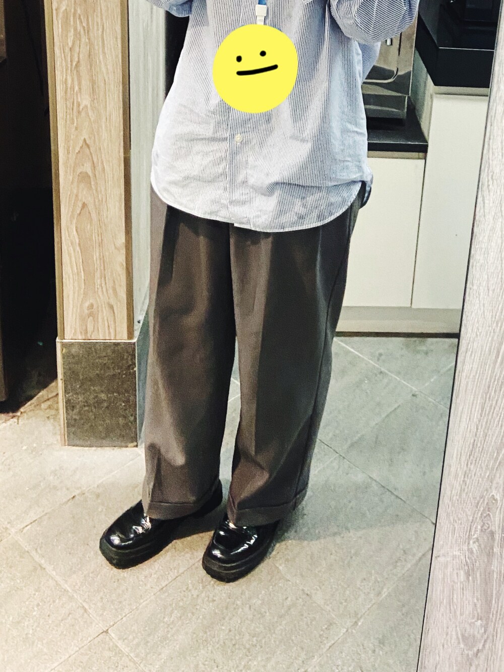 ブルー系のシャツ/ブラウス、グレー系のスラックス、ブラック系のローファーを着用したレディースの春コーディネートの2枚目の写真