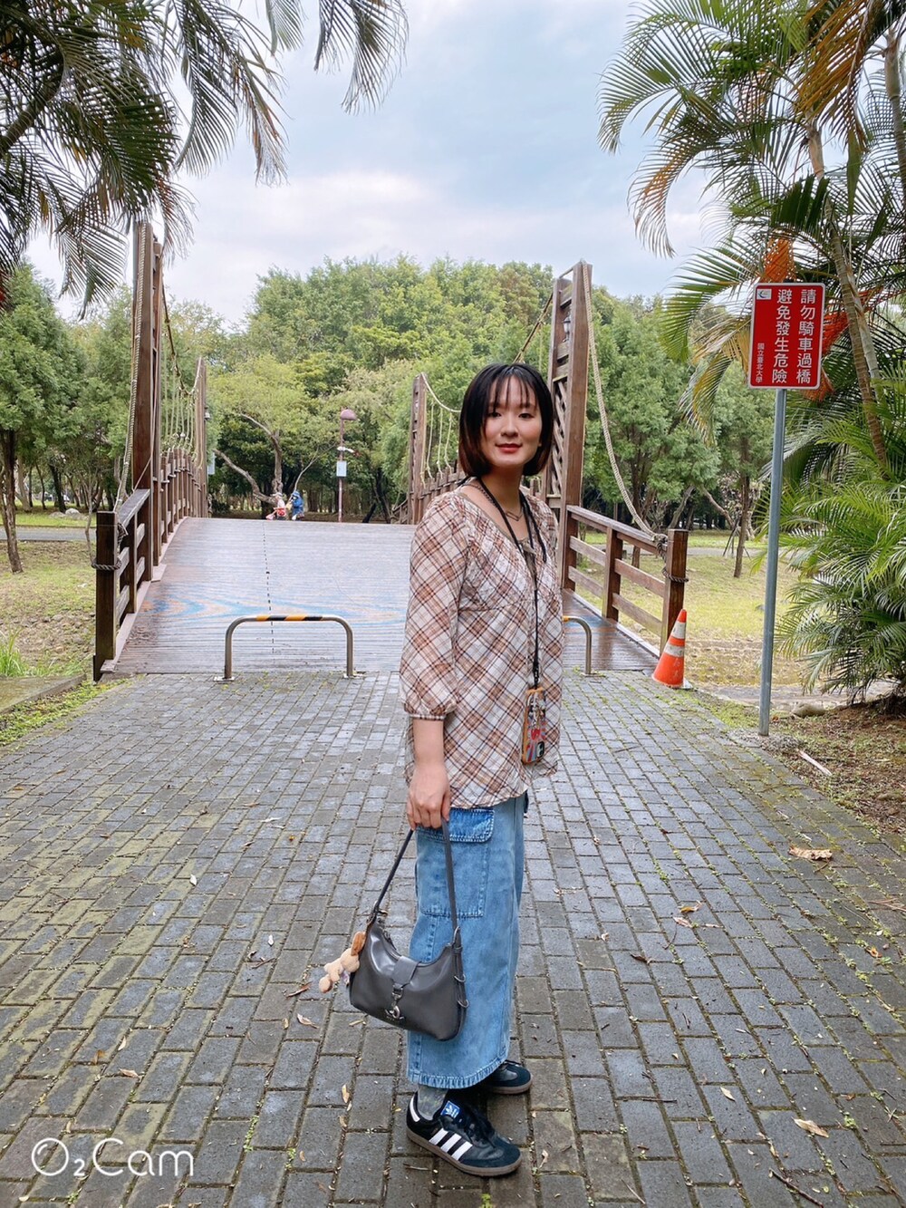 ブラウン系のTシャツ/カットソー、グレー系のショルダーバッグ、ブルー系のデニムスカートを着用したレディースの春コーディネートの5枚目の写真