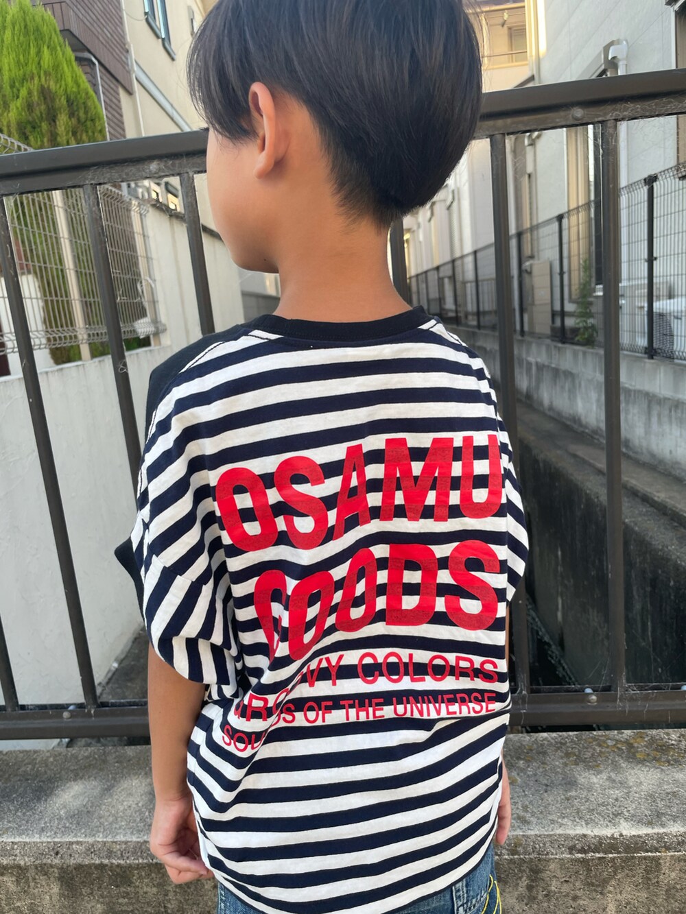 ブラック系のTシャツ/カットソー、ブルー系のパンツ、ブラック系のサンダルを着用したキッズの夏コーディネートの3枚目の写真