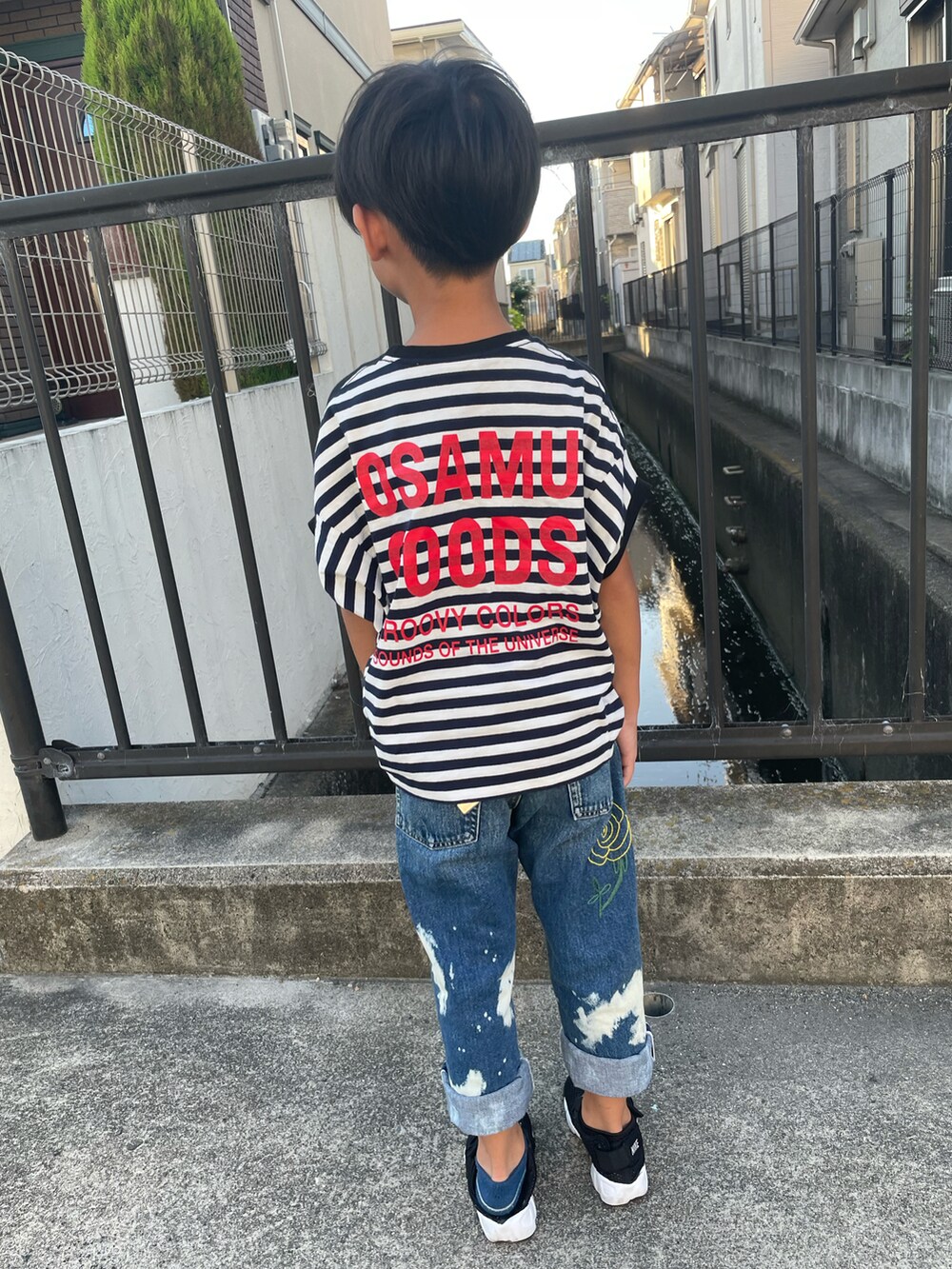 ブラック系のTシャツ/カットソー、ブルー系のパンツ、ブラック系のサンダルを着用したキッズの夏コーディネートの2枚目の写真