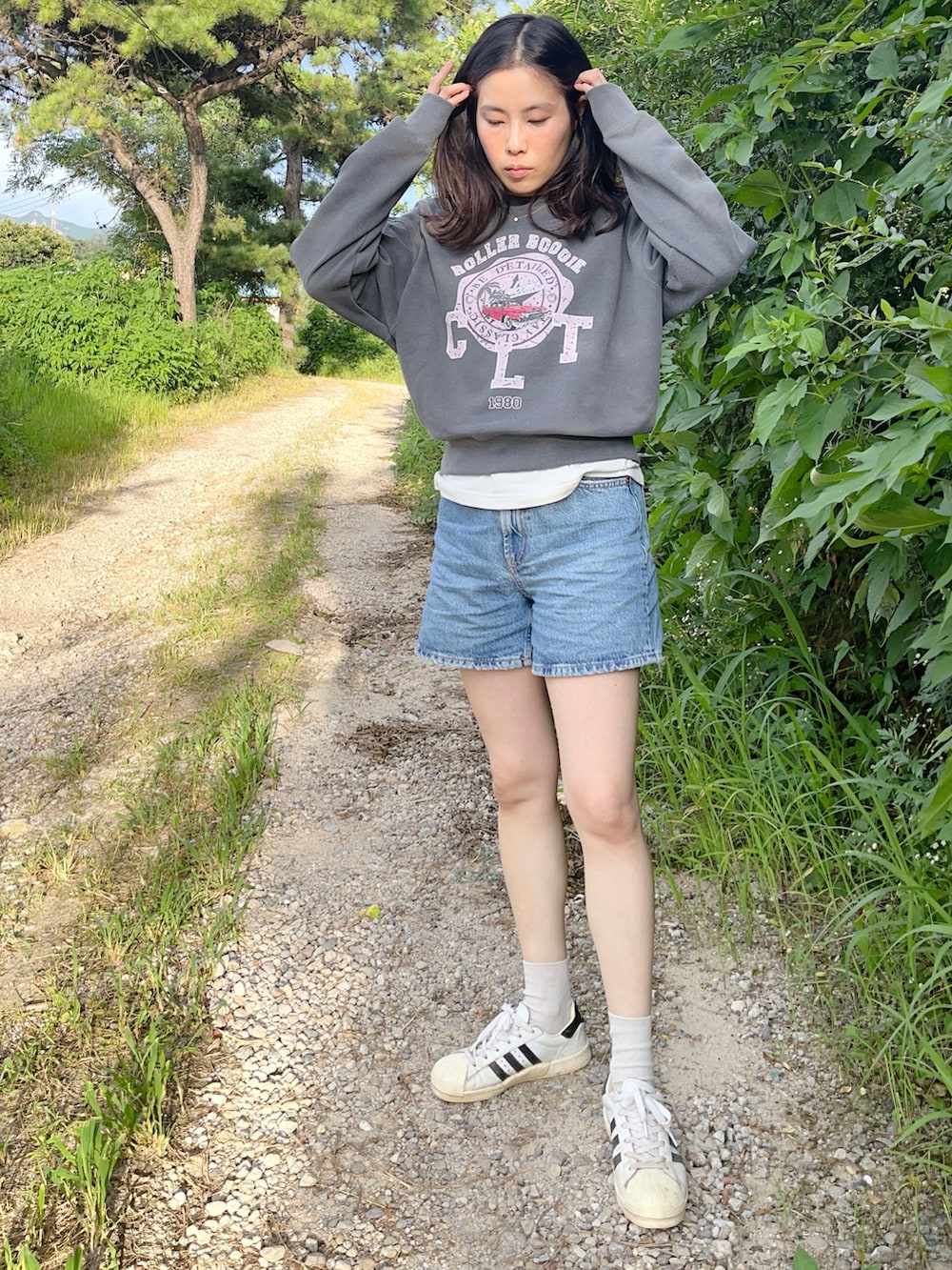 ブルー系のパンツ、グレー系のトップス、ホワイト系のスニーカーを着用したレディースの夏コーディネートの2枚目の写真