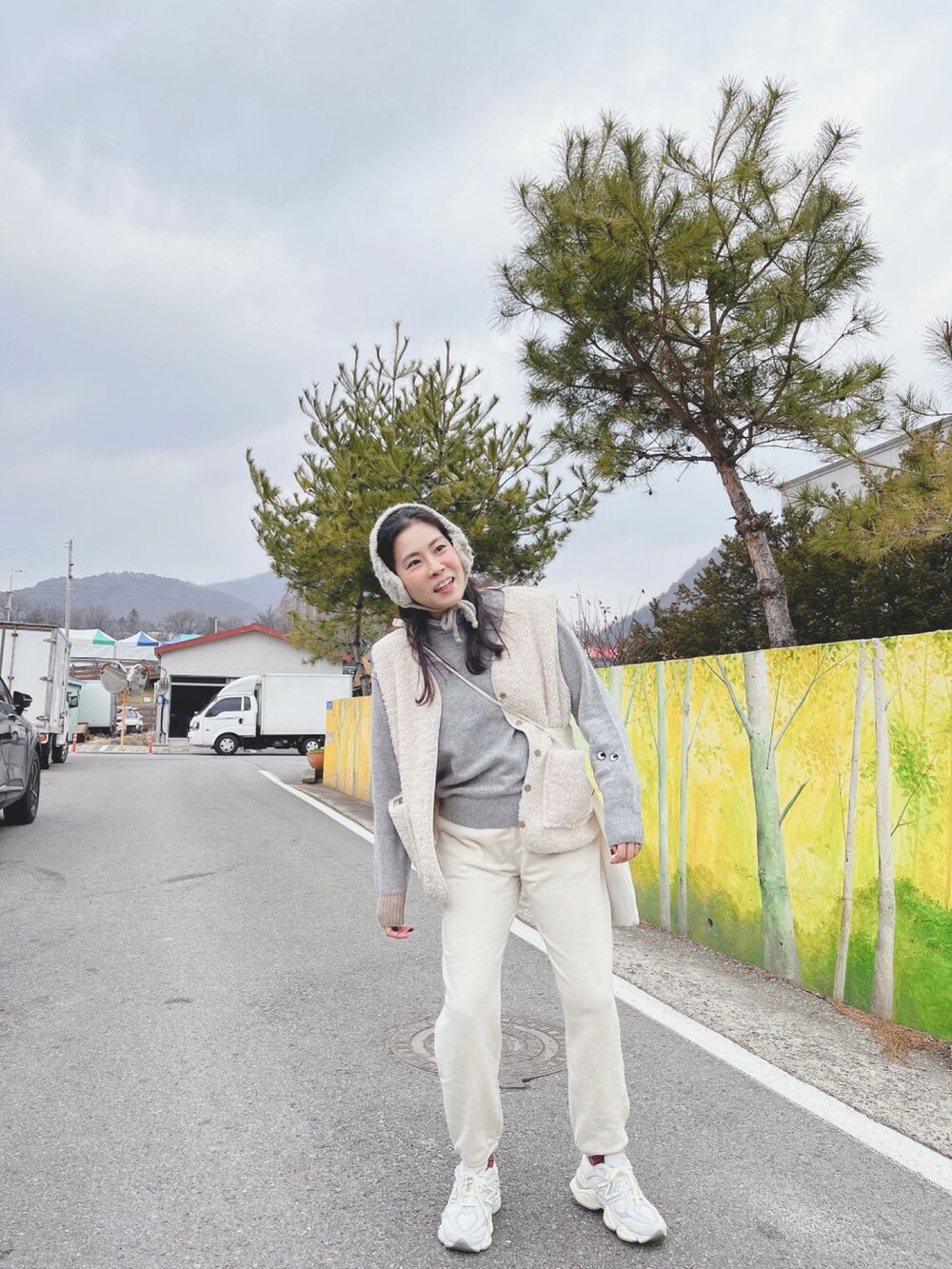 ホワイト系のパンツ、ホワイト系のスニーカー、グレー系のトップスを着用したレディースの冬コーディネートの2枚目の写真