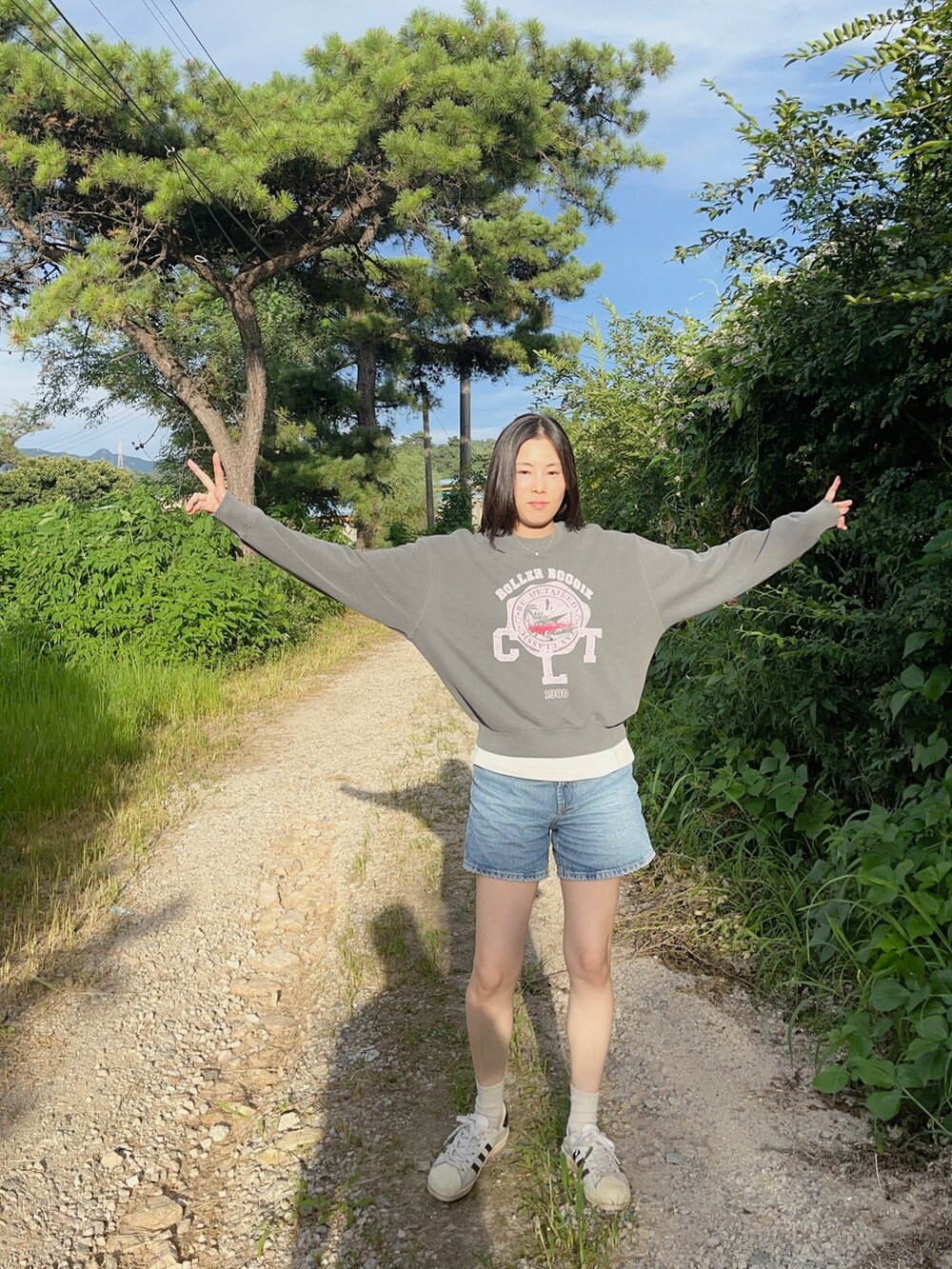 ブルー系のパンツ、グレー系のトップス、ホワイト系のスニーカーを着用したレディースの夏コーディネートの5枚目の写真