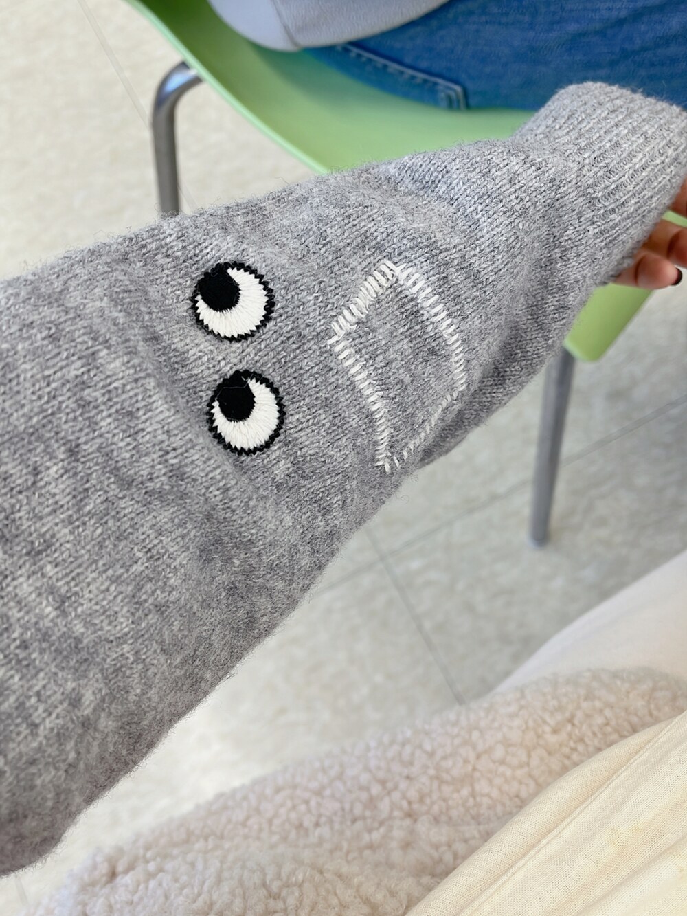 ホワイト系のパンツ、ホワイト系のスニーカー、グレー系のトップスを着用したレディースの冬コーディネートの3枚目の写真