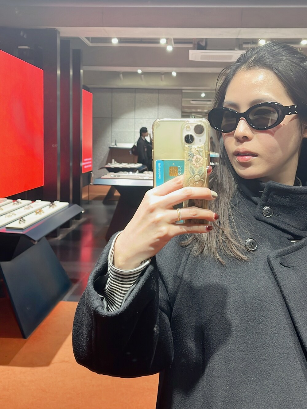 ブラック系のジャケット/アウター、ホワイト系のスニーカー、ブラック系のショルダーバッグを着用したレディースの冬コーディネートの5枚目の写真