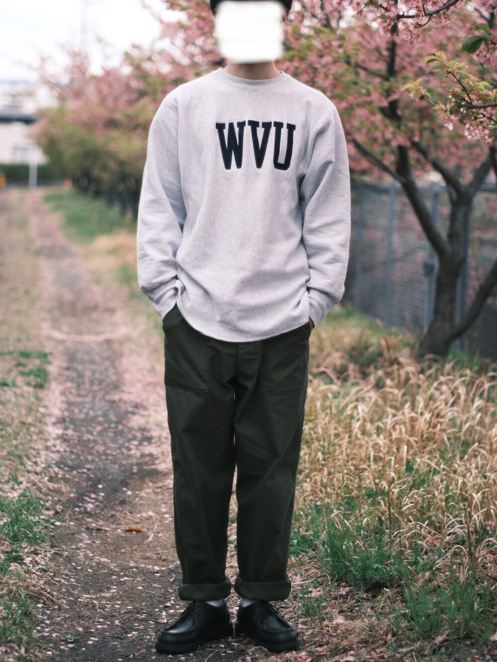 グリーン系のカーゴパンツ、ブラック系のドレスシューズ、グレー系のパーカーを着用したメンズの春コーディネートの2枚目の写真