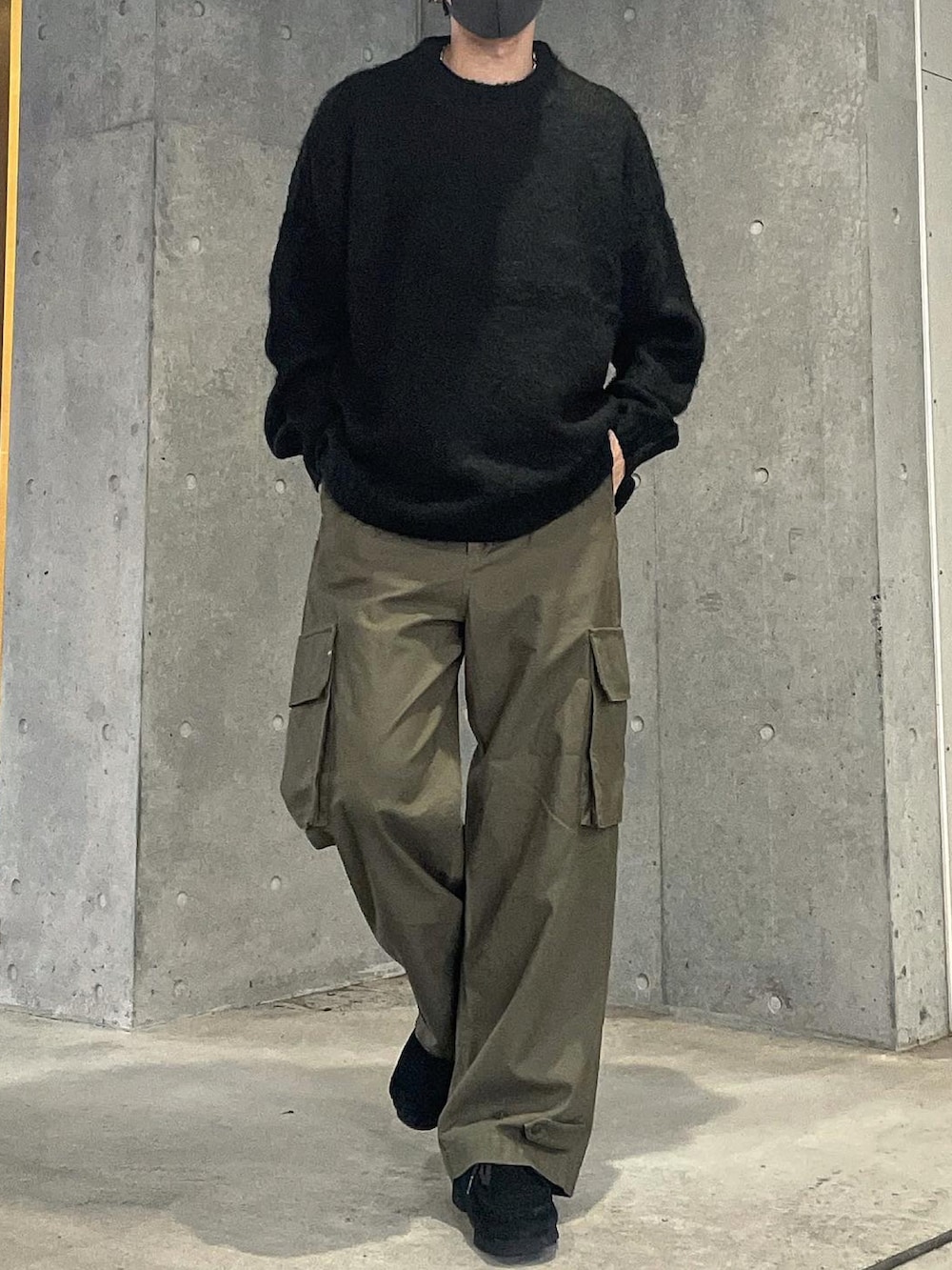 ブラック系のニット/セーター、グリーン系のカーゴパンツ、ブラック系のモカシン/デッキシューズを着用したメンズの秋コーディネートの2枚目の写真