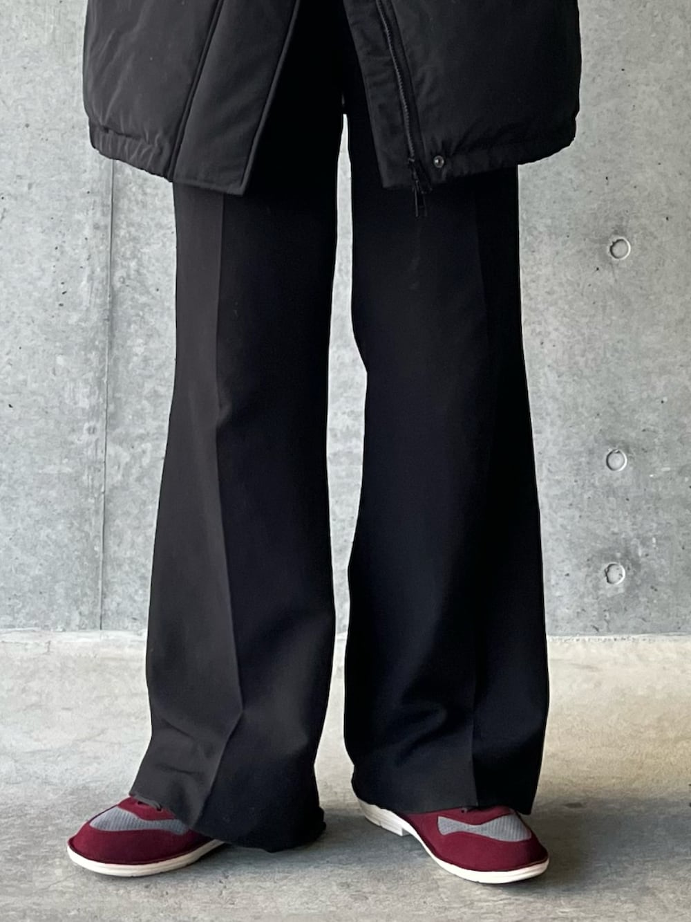 ブラック系のスラックス、レッド系のスニーカーを着用したメンズの秋コーディネートの2枚目の写真