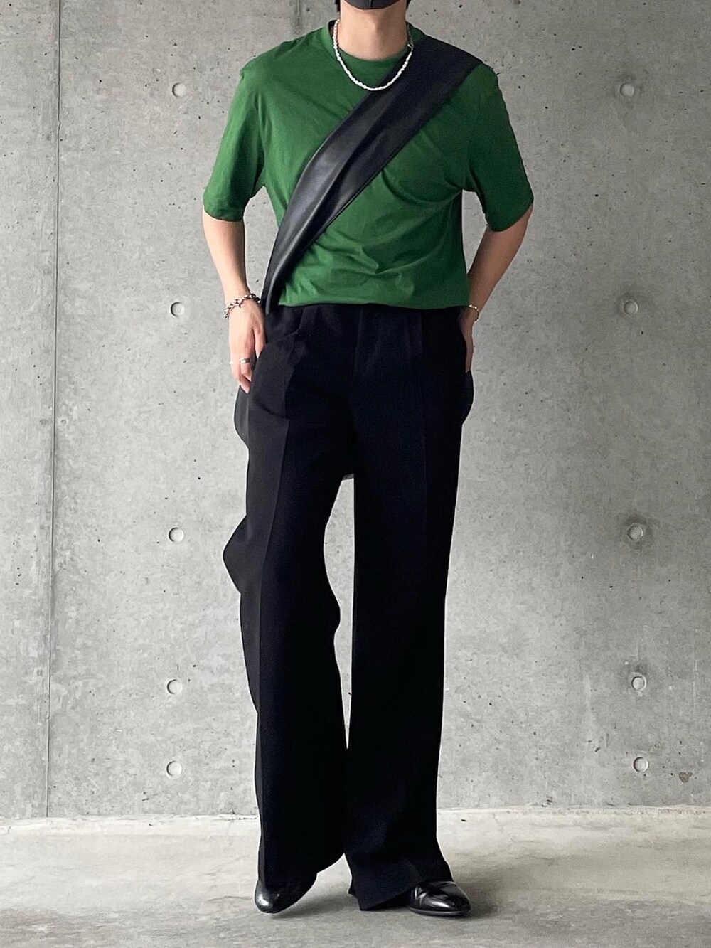 グリーン系のTシャツ/カットソー、ブラック系のスラックス、ブラック系のスリッポンを着用したメンズの夏コーディネートの2枚目の写真