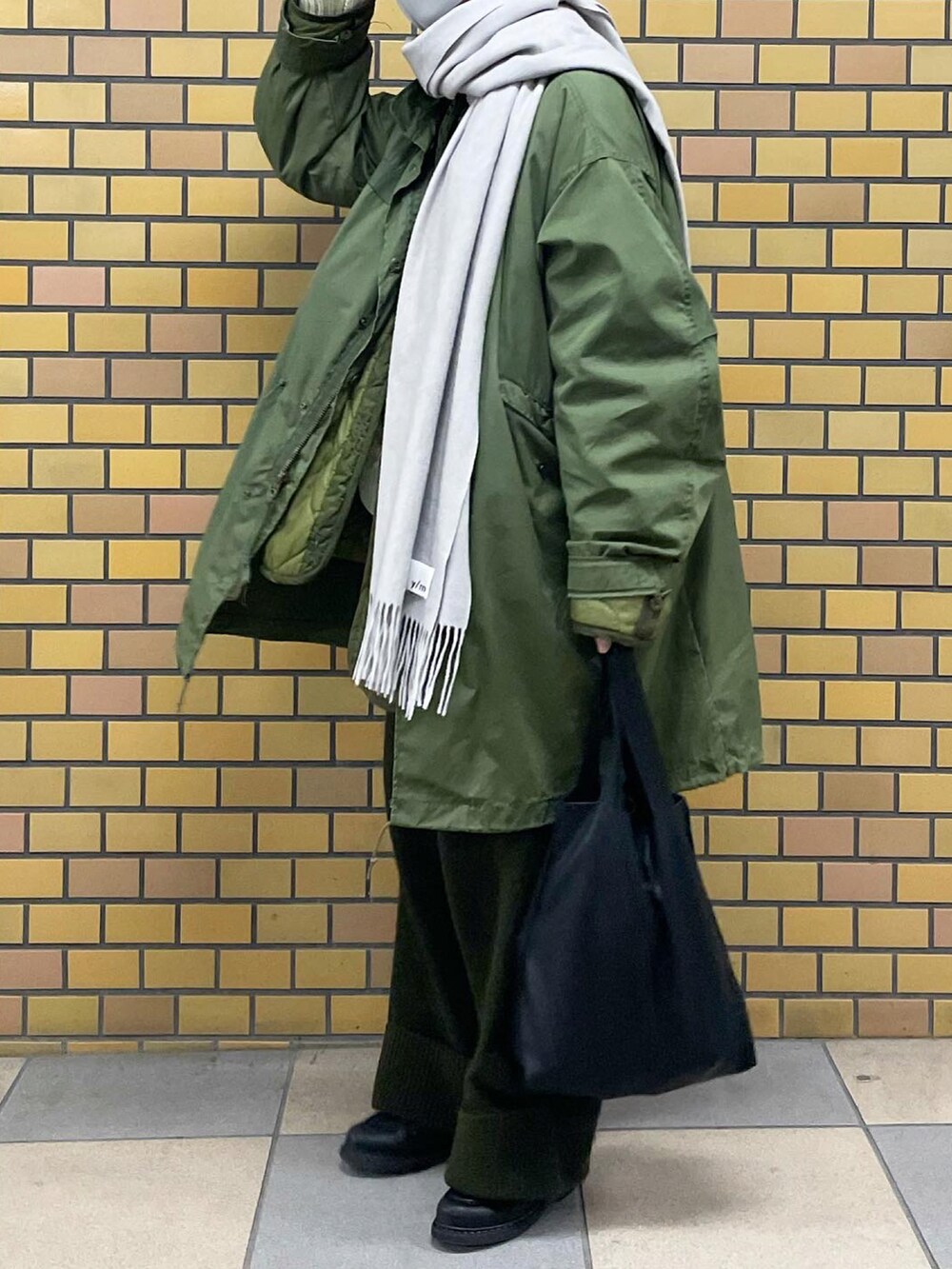 グリーン系のモッズコート、グリーン系のその他パンツ、ブラック系のドレスシューズを着用したメンズの冬コーディネートの2枚目の写真