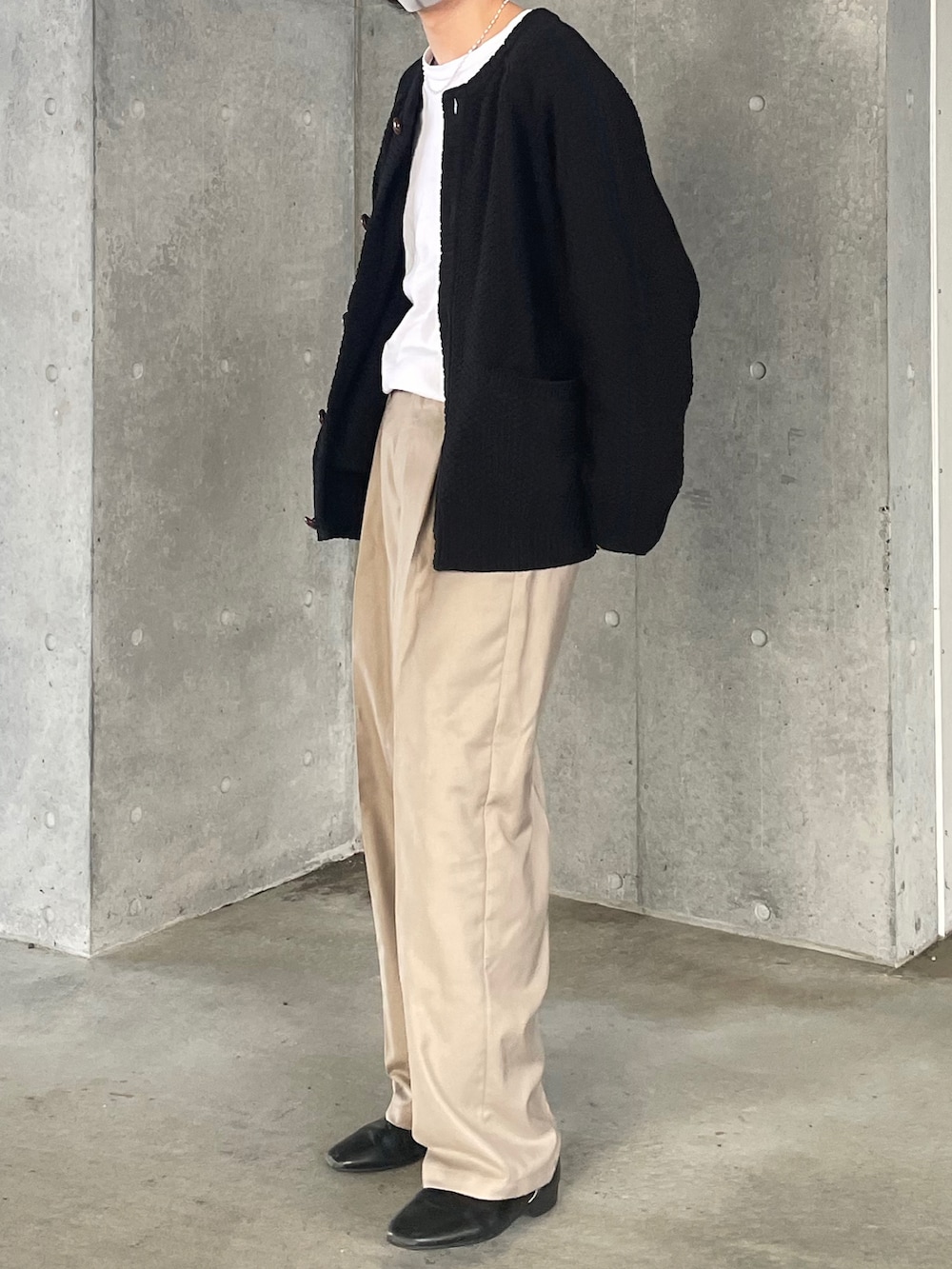ホワイト系のTシャツ/カットソー、ブラック系のカーディガン/ボレロ、ベージュ系のスラックスを着用したメンズの冬コーディネートの2枚目の写真