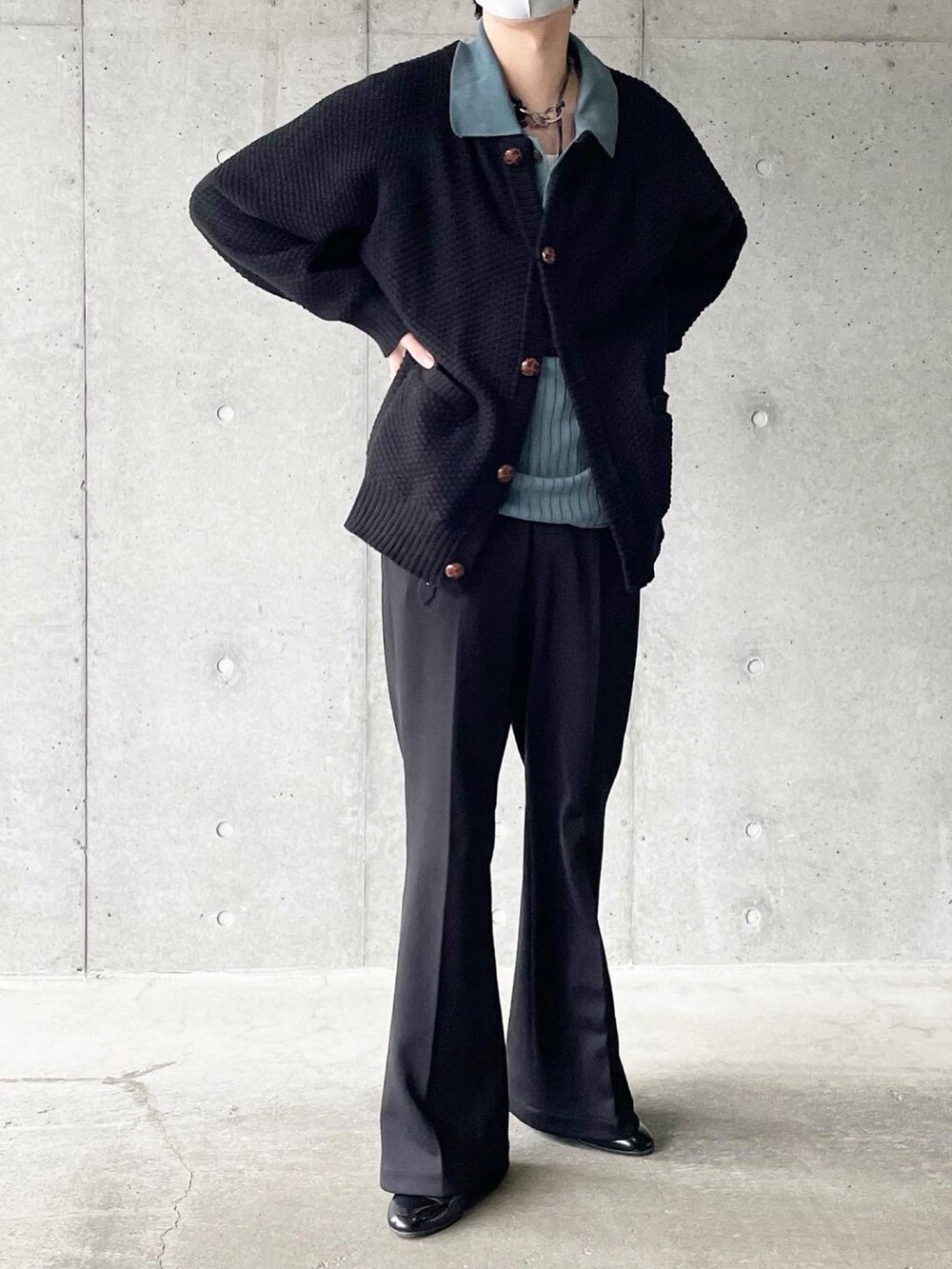 ブラック系のカーディガン/ボレロ、ブルー系のポロシャツ、ブラック系のスラックスを着用したメンズの春コーディネートの2枚目の写真