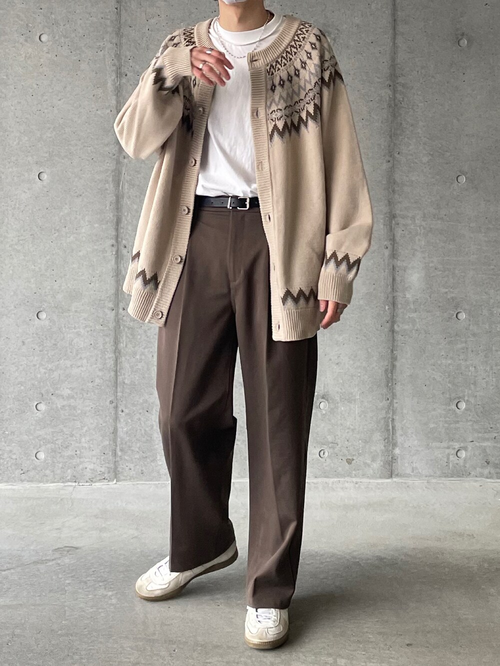 ベージュ系のカーディガン/ボレロ、ブラウン系のスラックス、ホワイト系のスニーカーを着用したメンズの冬コーディネートの2枚目の写真