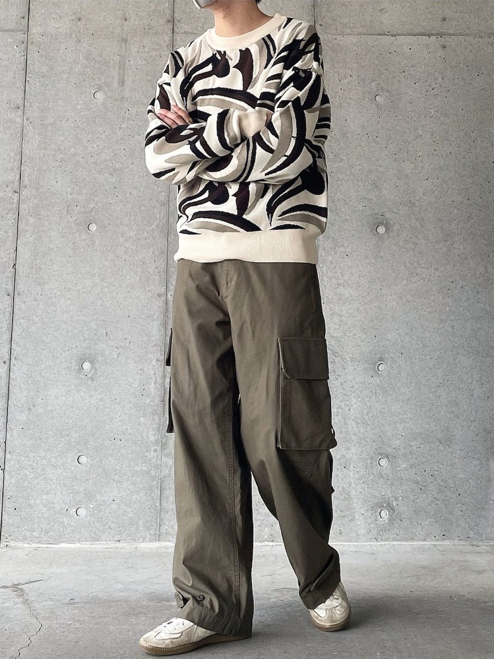 ホワイト系のニット/セーター、グリーン系のカーゴパンツ、ホワイト系のスニーカーを着用したメンズの秋コーディネートの2枚目の写真