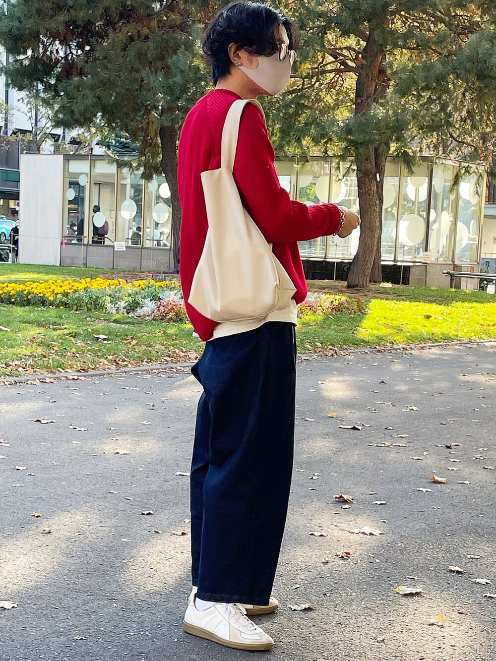 レッド系のニット/セーター、ブルー系のその他パンツ、ホワイト系のスニーカーを着用したメンズの秋コーディネートの2枚目の写真