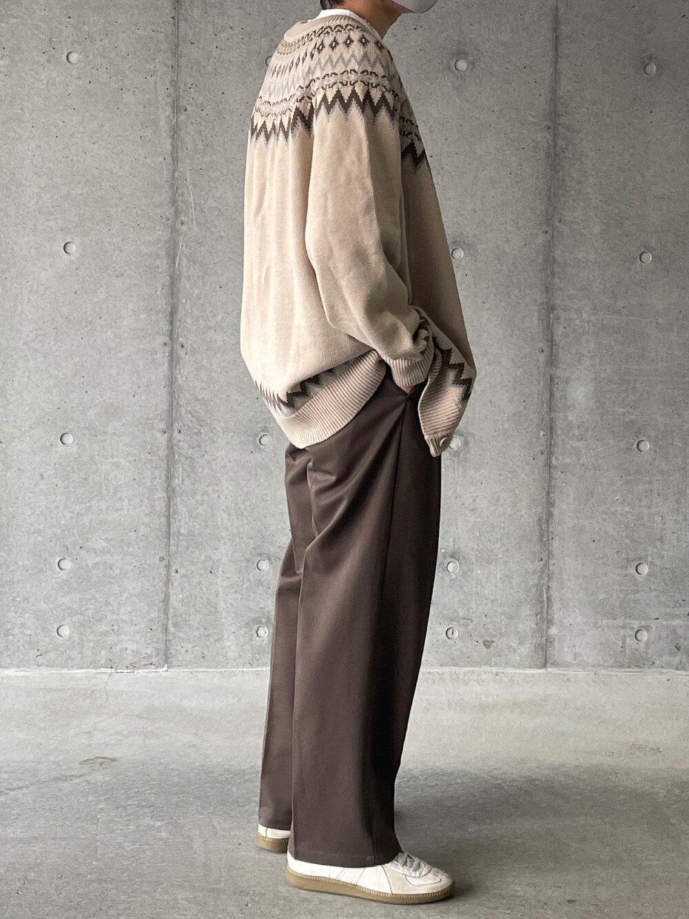 ベージュ系のカーディガン/ボレロ、ブラウン系のスラックス、ホワイト系のスニーカーを着用したメンズの冬コーディネートの3枚目の写真