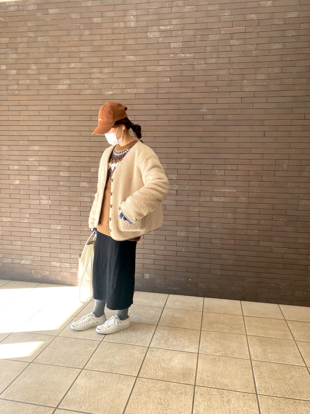 ベージュ系のジャケット/アウター、ホワイト系のスニーカー、ホワイト系のショルダーバッグを着用したレディースの冬コーディネートの2枚目の写真