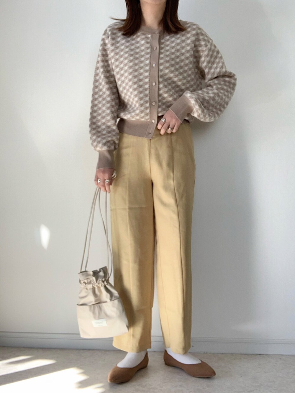 ホワイト系のニット/セーター、ブラック系のハンドバッグ、ブラック系のバレエシューズを着用したレディースの冬コーディネートの3枚目の写真